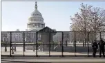  ?? JOHN MINCHILLO — THE ASSOCIATED PRESS ?? Capitol police officers stand outside of fencing that was installed around the exterior of the Capitol grounds in Washington on Thursday.