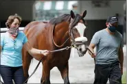  ?? SETH WENIG — THE ASSOCIATED PRESS ?? Robin Smullen, left, and Juan Barajas Saldana walk Belmont Stakes hopeful Tiz the Law around the paddock at Belmont Park in Elmont, N.Y., Thursday, June 18, 2020.