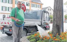  ??  ?? Andreas Kammerbaue­r besprengt die Blumen am Ehinger Marktplatz.