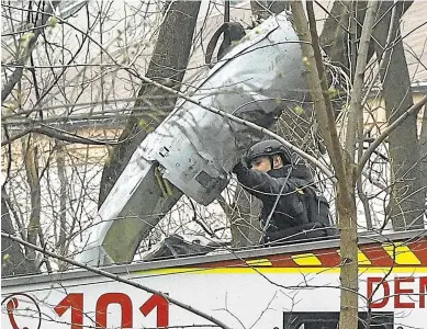  ?? SERGEY DOLZHENKO/EFE ?? Un miembro de los equipos de rescate examina los restos de un misil caído en un árbol.