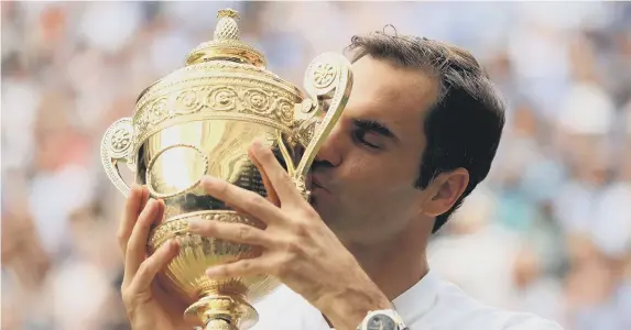  ??  ?? Roger Federer kisses the Wimbledon trophy.