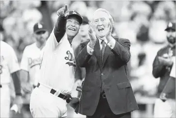  ?? Wally Skalij Los Angeles Times ?? VIN SCULLY and Dodgers manager Dave Roberts look on as the legendary broadcaste­r’s name is added to the “ring of honor” during a pregame ceremony at Dodger Stadium. Scully retired after last season.