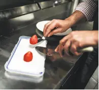  ??  ?? Bruno plates a dish of foie gras that is shaped like a strawberry and coated in berry gelee.