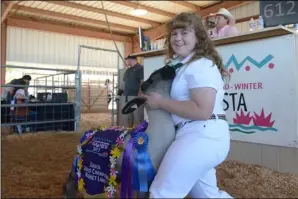  ??  ?? Audrey Galindo of Mulberry 4-H showcases her sheep, which was named Supreme Champion earlier in the week, during the California Mid-Winter Fair & Fiesta. Galindo’s sheep sold for $42.50 in Saturday’s auction. MARIO RENTERIA PHOTO