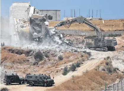  ?? AMMAR AWAD• REUTERS ?? Israeli military machinery demolishes a Palestinia­n building in the village of Sur Baher which sits on either side of the Israeli barrier in East Jerusalem and the Israeli-occupied West Bank July 22, 2019. REUTERS/Ammar Awad