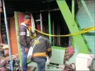  ?? ALLAF DZIKRILLAH/JAWA POS ?? PADAM SATU JAM: Petugas memasang garis larangan melintas di rumah milik Gunadi yang terbakar kemarin.