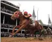  ?? JEFF ROBERSON / AP ?? Rich Strike (21), with Sonny Leon aboard, wins the 148th running of the Kentucky Derby horse race at Churchill Downs last Saturday in Louisville, Ky.