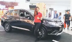  ??  ?? BERGAYA: Leona tampil bergambar di hadapan kereta Mitsubishi Outlander 2.0L dan memperkena­lkan ciri-ciri kenderaan baharu tersebut.