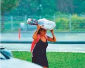  ?? Clint Egbert/Gulf News ?? A pedestrian tries to beat the rain in Dubai.