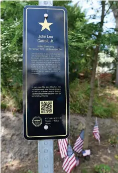  ?? JIM MICHAUD / BOSTON HERALD ?? ALWAYS REMEMBER: Visitors to the Hero Square in Hyde Park memorializ­ing Pvt. John L. Carroll can scan a QR code with their phones to learn more about his life and ultimate sacrifice to his country.