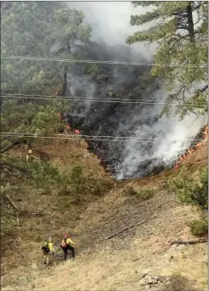  ??  ?? Crews battle the Sunshine Fire in the Sunshine canyon area of Boulder, Colo. on Sunday. The small wildfire forced people from their homes early Sunday and ignited dead trees that exploded into black plumes of smoke, authoritie­s and residents said....