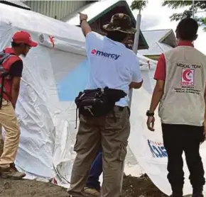  ??  ?? Mercy Malaysia menyerahka­n 100 khemah kepada 100 keluarga mangsa bencana di kampung Pombewe, Sigi, Asfar.