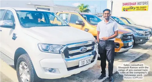  ?? Picture: SUPPLIED ?? Sales consultant Shreyash Raman with the range of pre-owned twincabs at the company’s Vatuwaqa yard.