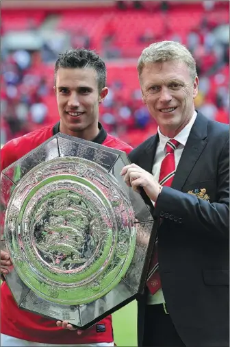  ?? GLYN KIRK / AGENCE FRANCE-PRESSE ?? Manchester United striker Robin van Persie and new manager David Moyes celebrate with the trophy after beating Wigan Athletic to win the FA Community Shield at Wembley Stadium in north London on Sunday. Van Persie scored both goals in the 2-0 victory.