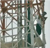  ?? — DC ?? The parent of a student checks his mobile phone atop a cellphone tower at Vijayawada on Sunday.