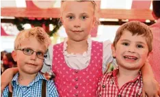  ??  ?? Johannes, Franziska und Sebastian (von links) gefällt das Günzburger Volksfest – und die Kleidung, die sie tragen.