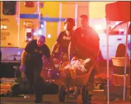  ?? Chase Stevens / Associated Press ?? A wounded person is taken in a wheelbarro­w as police respond to a shooting on the Las Vegas Strip Sunday.