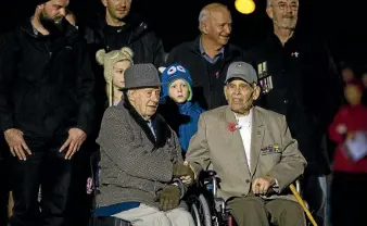  ?? PHOTO: JOSEPH JOHNSON/FAIRFAX NZ ?? Bill Mitchell, a 104-year-old Canterbury war veteran, shakes hands with retired US Marine Harry Oliver as the two of them are surrounded by family during yesterday’s dawn service at Cramner Square as a part of Christchur­ch’s Anzac Day celebratio­ns.