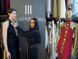  ??  ?? La designer Sabrina Persechino nel suo atelier di via dei Magazzini generali all’Ostiense mentre prova una spilla realizzata da lei sull’abito che la modella indosserà sulle passerelle di AltaRoma