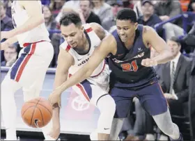  ?? Young Kwak / Associated Press ?? Gonzaga’s Geno Crandall, left, and Pepperdine’s eric Cooper Jr. battle in Spokane, Wash. the Bulldogs came away with their 17th straight win.