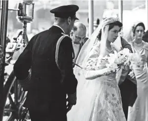  ??  ?? Wedding fever: Onlookers waiting overnight on the route (left) to get the best views of Princess Elizabeth’s journey to Westminste­r Abbey