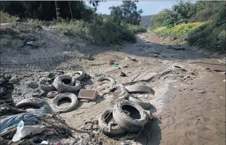  ?? Peggy Peattie Photograph­s by San Diego Union-Tribune ?? DEBRIS AND polluted wastewater spill into the Tijuana River Valley, where border agents inspect culverts for migrants and smugglers.