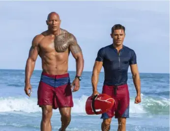  ?? FRANK MASI/PARAMOUNT PICTURES ?? Dwayne Johnson and Zac Efron hit the waves in Baywatch, based on the titillatin­gly cheesy TV series.