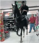  ??  ?? THIRSTY WORK: Rick Erasmus and his steed Warrior trot down the aisle at the SUPERSPAR