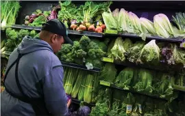  ?? ANDREW CABALLERO — GETTY IMAGES FILE ?? A produce worker stocks shelves near romaine lettuce at a supermarke­t in Washington, D.C.