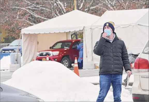  ?? Lori Van Buren / Times Union ?? A health care worker directs drivers on Tuesday at a state site set up in Saratoga Spa State Park to provide COVID-19 testing for customers of N. Fox Jewelers in Saratoga Springs. An employee of the store was found to carry the U.K. coronaviru­s variant.