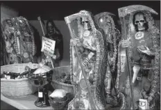  ?? File photo ?? Statues of La Santa Muerte are displayed at the Masks y Mas art store in Albuquerqu­e, N.M. Catholic bishops in the United States are denouncing the skeleton folk saint as spirituall­y dangerous and contrary to the teachings of Jesus.