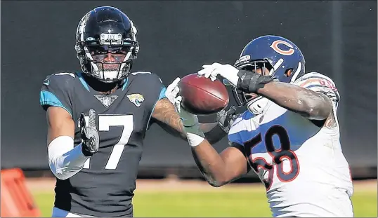  ?? STEPHEN B. MORTON/AP ?? Roquan Smith intercepts a pass intended for Jacksonvil­le Jaguars wide receiver DJ Chark Jr. at the end of the first half. Smith’s intercepti­on would lead to a field goal before halftime, breaking a 10-10 tie.