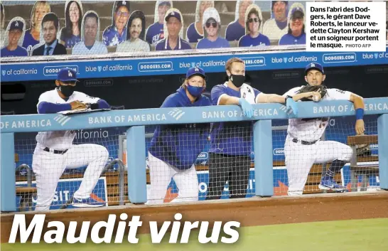  ?? PHOTO AFP ?? Dans l’abri des Dodgers, le gérant Dave Roberts, le lanceur vedette Clayton Kershaw et un soigneur portent le masque.