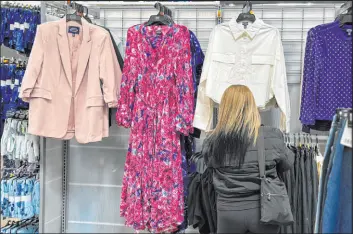  ?? Anne D’innocenzio The Associated Press ?? A shopper looks at clothes at a Walmart store in Secaucus, N.J. Retail sales increased by 0.7 percent in March, almost double of what economists had forecasted.