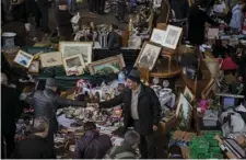  ?? PHOTO/ ?? People buy items at a street stall in Barcelona, Spain on Monday. Jittery businessme­n in Catalonia have put their investment plans on ice as they brace for the region’s parliament­ary election on Thursday. Investors are spooked by signs the recent...