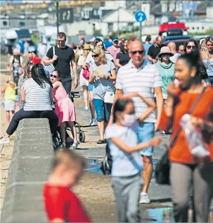  ?? Picture: ?? Sunworship­pers crowded onto Ayr beach yesterday as temperatur­es soared. But the surge in visitors raised fresh fears over social distancing
Andrew Cawley