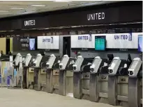  ?? AP PHOTO/CHRIS O’MEARA ?? Empty United Airlines ticket machines are seen in April at the Tampa Internatio­nal Airport in Tampa, Fla. United Airlines will send layoff warnings to 36,000 employees — nearly half its U.S. staff — in the clearest signal yet of how deeply the virus outbreak is hurting the airline industry.