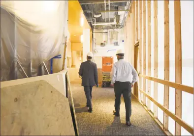  ??  ?? Library Board of Trustees President Thomas Heagney, left, and Buildings and Grounds Committee Chairman Hank Ashforth lead a tour of the renovation at Greenwich Library last month.