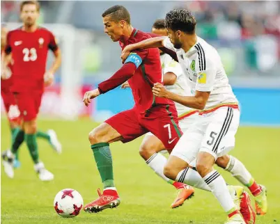  ??  ?? RONALDO (kiri) menggelece­k melepasi dua pemain Mexico pada perlawanan di Kazan Arena, Kazan Ahad lepas. — Gambar Reuters