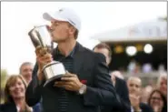  ?? (JOHN WOIKE - HARTFORD COURANT VIA AP ?? Jordan Spieth kisses the 2017 Travelers Championsh­ip trophy after holing a bunker shot for birdie in a playoff with Daniel Berger at TPC River Highlands in Cromwell, Conn., Sunday.