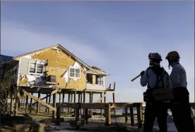  ?? AP photo ?? A home stands damaged from Hurricane Michael as members of a South Florida urban search-and-rescue team look for survivors in Mexico Beach, Fla., on Friday.