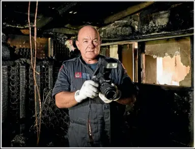  ?? DOMINICO ZAPATA/STUFF ?? Fire inspector Kevin Holmes takes photos of the evidence inside the flat.