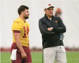  ?? ALEX BRANDON/AP ?? Commanders quarterbac­k Sam Howell, left, talks with coach Ron Rivera during minicamp before the 2022 season. Rivera has said Howell is the likely starter but will have to earn the job.