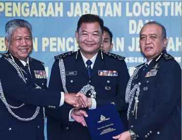  ?? — bernama ?? Winds of change: abdul Hamid (centre) watching as outgoing bukit aman Logistics and Technology department director comm Tajudin (left) hands over the position to comm rosli at the bukit aman police headquarte­rs in Kuala Lumpur.