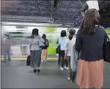  ?? EUGENE HOSHIKO/AP PHOTO ?? Commuters wait to get on a train Wednesday in Tokyo. A police-developed app with anti-sex crime alarms has won massive subscripti­ons as Japanese women try to arm themselves against gropers on packed rush-hour trains.