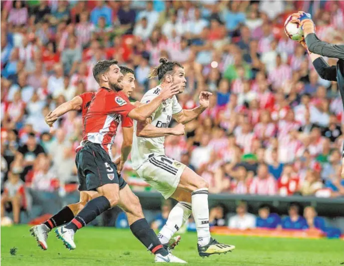  ??  ?? Unai Simón se hace con la pelota ante la presión del madridista Gareth Bale