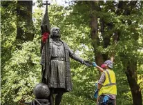  ?? DAVE SANDERS/THE NEW YORK TIMES ?? Colombo. Trabalhado­r limpa tinta das mãos da estátua