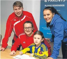  ??  ?? Skye Gourlay (6) signs for Dundee West Ladies watched by, from left, Tam McCabe, Laura-Anne Johnston (coach) and Sam Milne (SFA Ladies Developmen­t Officer).