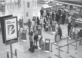  ?? JOHN MINCHILLO/AP FILE ?? Travelers wait to check in for their flights Nov. 25, the day before Thanksgivi­ng, at New York’s Laguardia Airport. Nearly 5 million Americans took to the skies around the holiday.