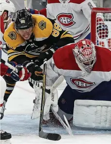  ??  ?? UP TO TASK: Bruins star David Pastrnak battles in front of the net as Montreal Canadiens goaltender Carey Price makes a save.